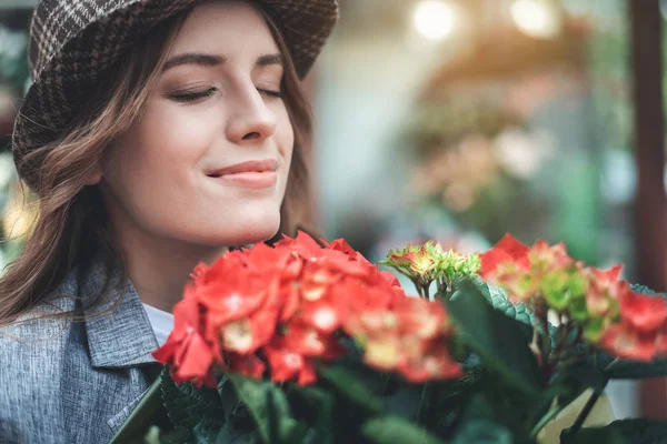 Весела жінка насолоджується квітковим ароматом надворі — стокове фото