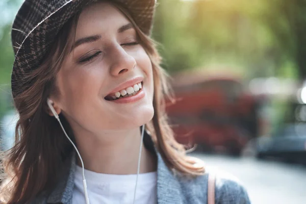 Bella joven está escuchando música con sonrisa — Foto de Stock