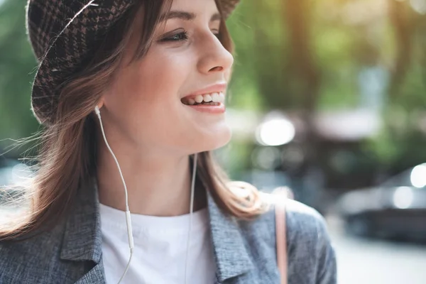 Souriant jolie femme utilisant des écouteurs — Photo