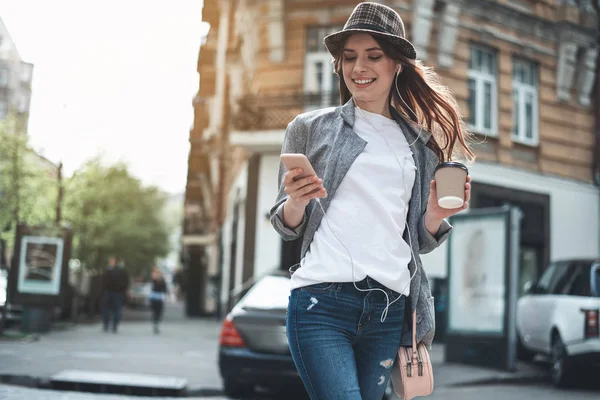 Senhora alegre com telefone celular e café fora — Fotografia de Stock