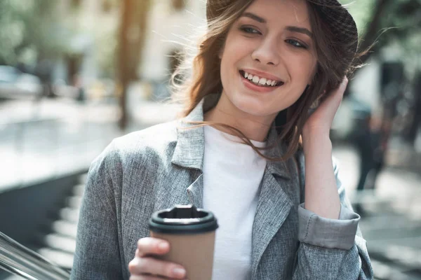 Sonriente jovencita sosteniendo bebida caliente afuera —  Fotos de Stock