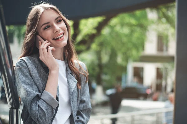 Sonriendo bastante joven mujer hablando en el teléfono inteligente — Foto de Stock
