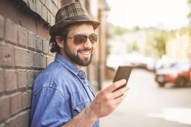 Şık adam dışında dururken Smartphone kullanarak