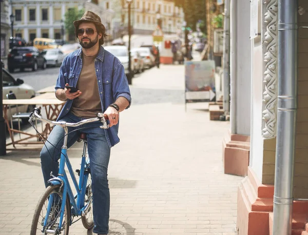 Ernstige man gadget gebruiken tijdens het fietsen — Stockfoto