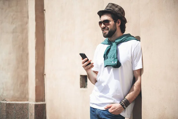 Atraktivní muž osoba požívající využití jeho telefon venku — Stock fotografie