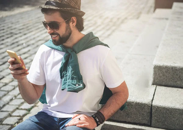 Stilig man vilar utanför med enhet — Stockfoto