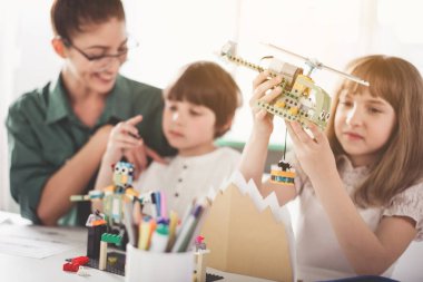 Neşeli öğretmen ve oyuncakları ile oynarken çocuklar
