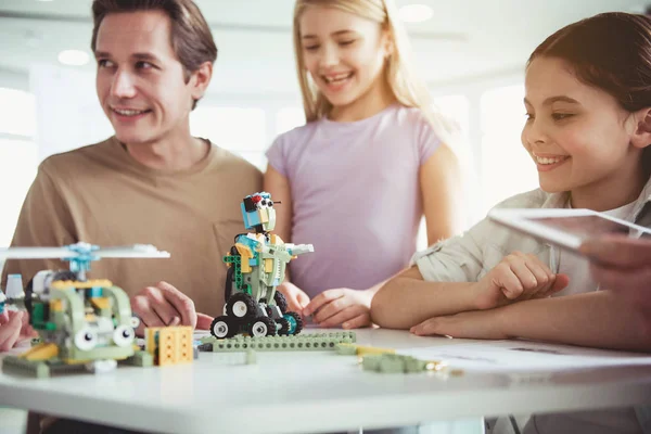 Happy children and adult watching at toys — Stock Photo, Image