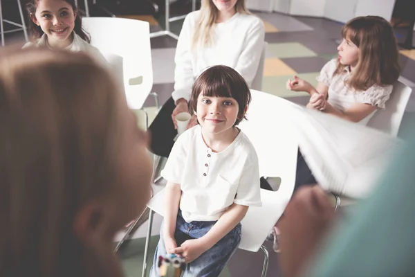 Criança sorridente localizando na sala de aula — Fotografia de Stock