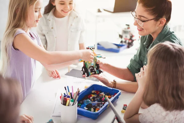 Mujer positiva y niños creando robot —  Fotos de Stock