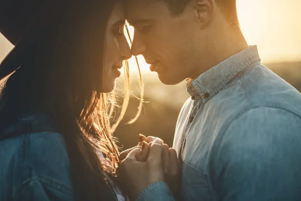 Merry man and woman embracing before sunset — Stock Photo, Image