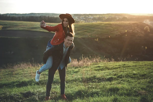 Amar alegre mujer y el hombre alrededor de verdes colinas —  Fotos de Stock