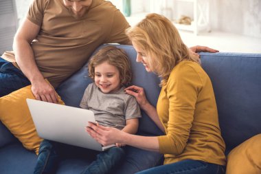 Mutlu bir aile evde laptop kullanıyor