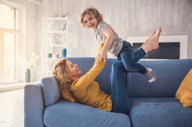 Neşeli anne küçük oğlu oturma odasında eğlenceli