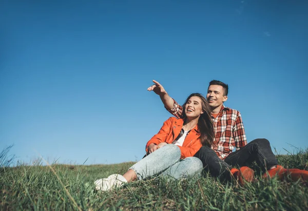 夏には丘の上に座って笑顔のカップル — ストック写真