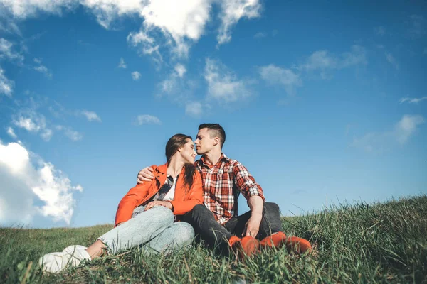 Sevgi dolu çift kucaklamaları çimenlerin üzerinde oturan