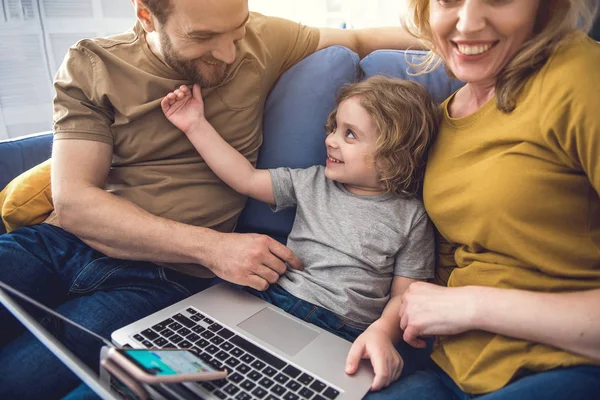 Grijnzende ouders en zoon genieten van moderne gadgets — Stockfoto