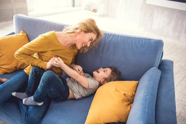 Verlaten moeder en zoon zijn vermakelijk in woonkamer — Stockfoto