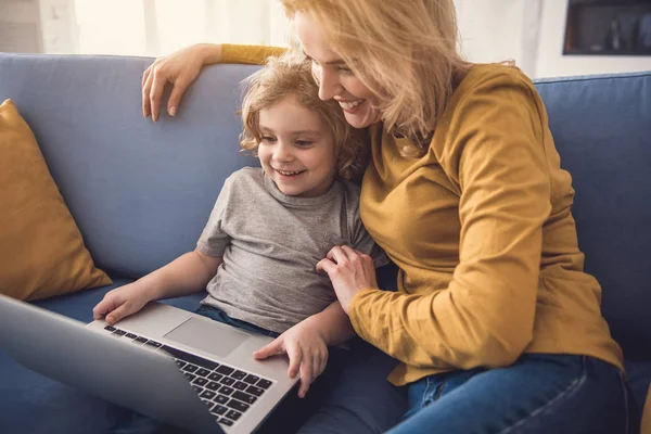 Gülümseyen anne ve oğlu laptop kapalı kullanarak tadını çıkarıyor — Stok fotoğraf