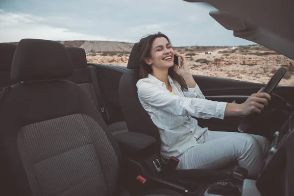 Gioiosa giovane donna che parla su smartphone in auto convertibile — Foto Stock