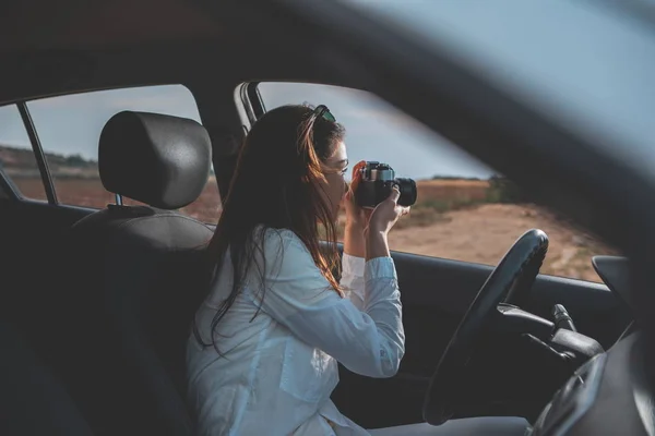 Excited girl taking photos of nature inside the transport — Stock Photo, Image