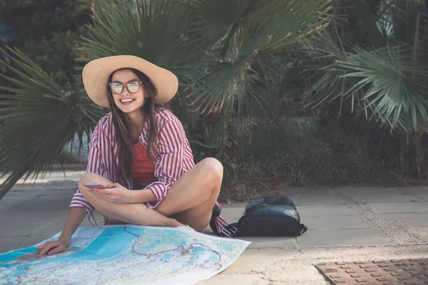 Vzrušená dívka čtení mapu a držení telefonu venkovní — Stock fotografie