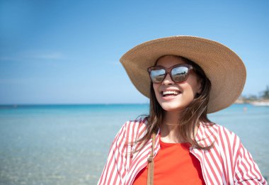 Neşeli genç kadın okyanus yakın dinlenme sırasında sevinç ifade