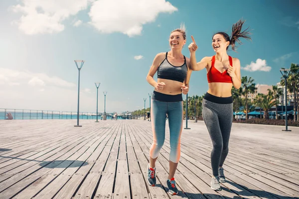 Filles excitées jogging le long de la mer — Photo