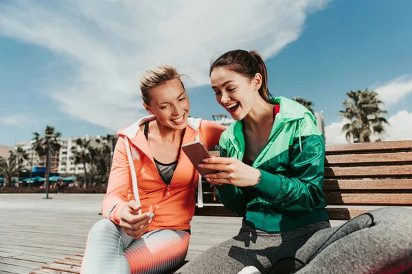 Despreocupado mujeres jóvenes que se divierten con gadget al aire libre —  Fotos de Stock