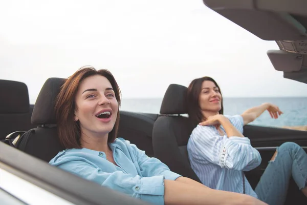 Roztomilé mladé ženy se usmívají v auto — Stock fotografie