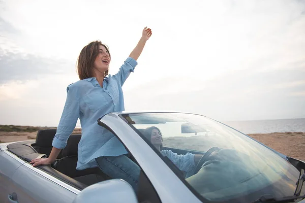 Cheerful female friends are travelling by auto — Stock Photo, Image