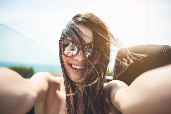 Feliz hermosa mujer está tomando una foto de sí misma —  Fotos de Stock