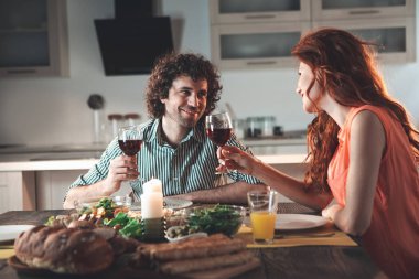 Neşeli erkek ve kadın mutfakta şarap içme 