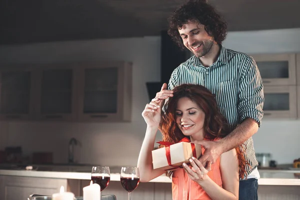 Mujer feliz recibiendo regalo de hombre en casa — Foto de Stock