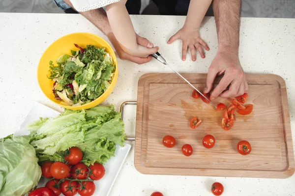 Папа и ребенок делают салат на кухне — стоковое фото