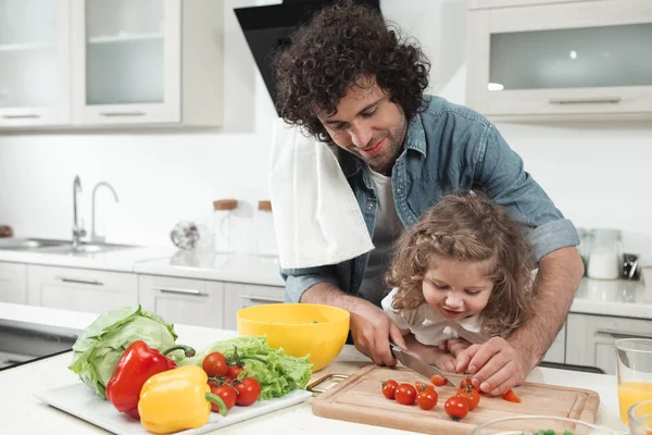 Curious daughter is looking how her dad preparing lunch — Stock Photo, Image