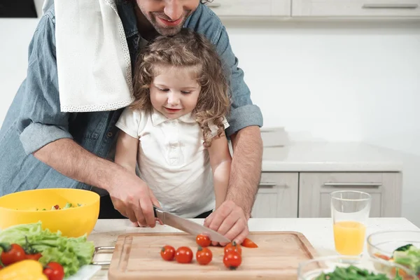 Frumos copil uitându-se la tatăl ei făcând salată — Fotografie, imagine de stoc