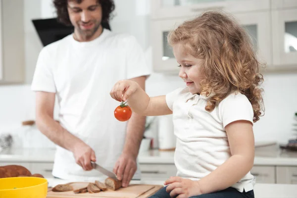Nyfiken kvinna barn stirrar på grönsak i kök — Stockfoto