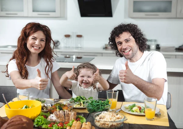 Pais alegres e criança mostrando sinal ok enquanto come — Fotografia de Stock