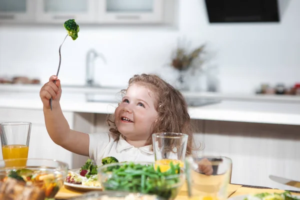 Happy female child is eating healthy food with enjoyment — Stock Photo, Image