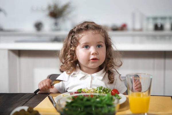 Criança bonita comendo legumes saudáveis em casa — Fotografia de Stock