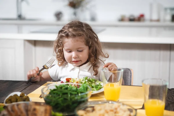 Cheerful female kid eating healthy food at home — Stock Photo, Image
