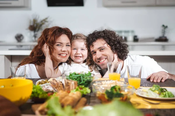 Pais alegres e filha almoçando juntos — Fotografia de Stock