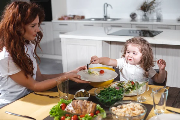 Cheerful mother and daughter having lunch together — Stock Photo, Image