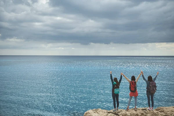 Mujeres jóvenes emocionadas contemplando el paisaje marino con admiración — Foto de Stock