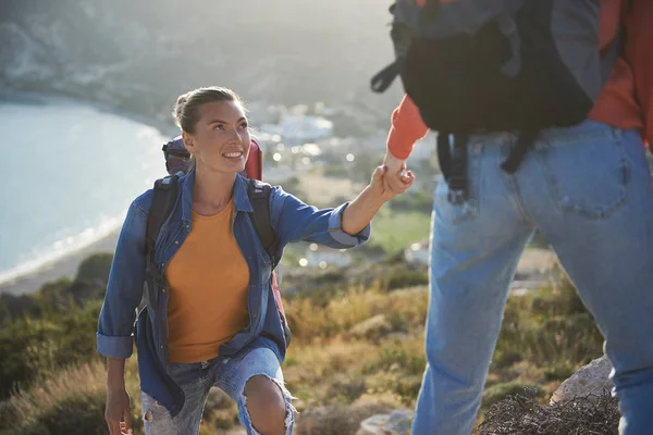 Toeristen die de top van de heuvel klimmen — Stockfoto