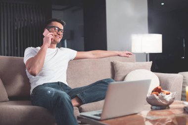 Neşeli adam cep telefonu evinde konuşurken 