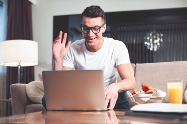 Neşeli adam online iletişim için bilgisayar kullanarak 