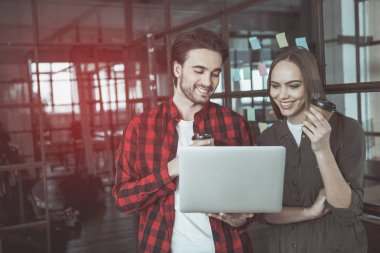 İyimser erkek ve kadın iş yerinde espresso tadını çıkarıyor