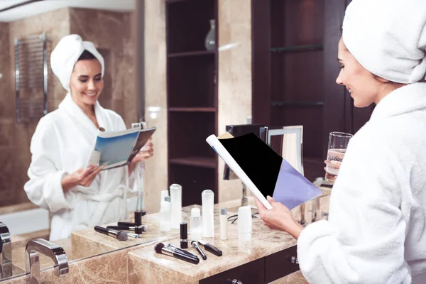 Mutlu kız banyoda dergi okuma kafa havluya ile